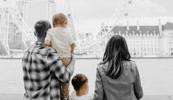 A family stands looking over a river.