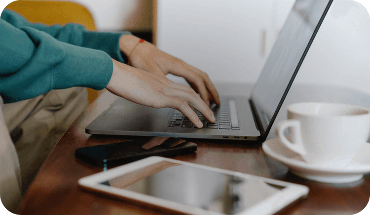 A therapist types on a laptop wondering about what it means to be HIPAA compliant as a therapist
