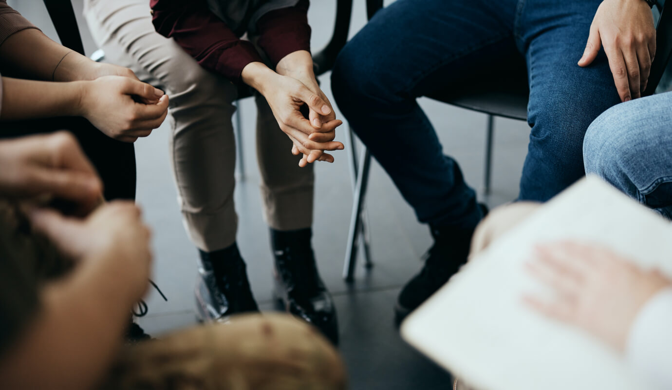 Clients sit in a circle next to therapist who's implementing group therapy room design best practices