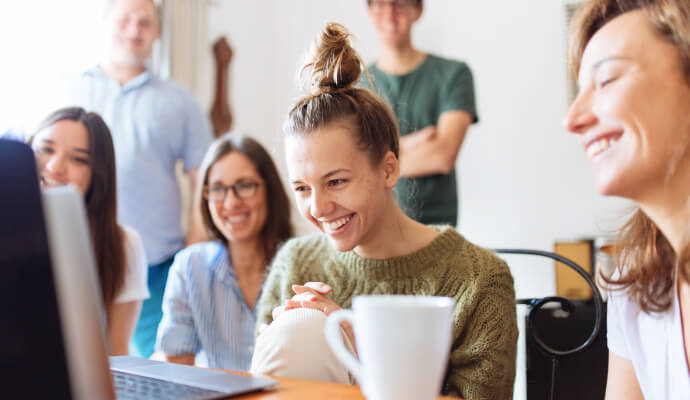 A group of people are sitting together, talking and drinking coffee.