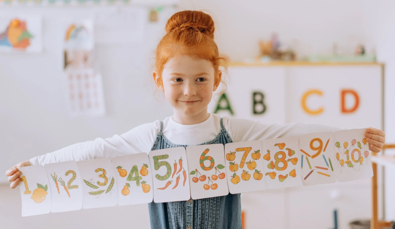 A child client shows her SLP a speech therapy door decoration, meant to help with counting and pronunciation