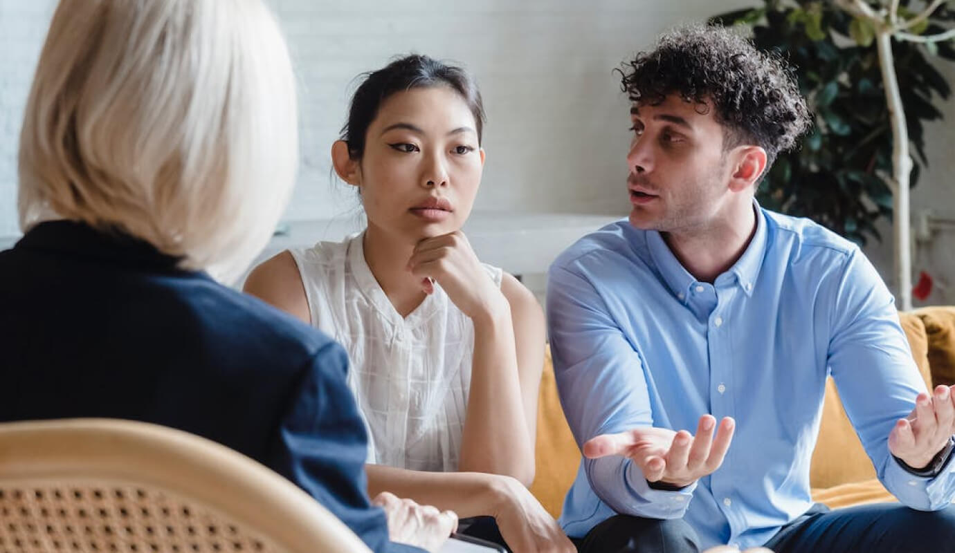 A therapist prompts her clients to answer couples therapy questions, in session.